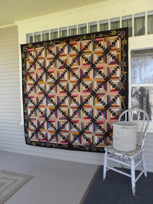 scrappy lap quilt pattern with floral applique accent