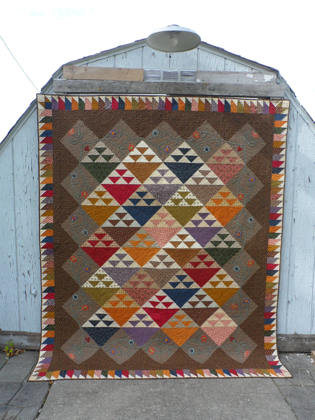 scrappy large quilt pattern with applique and scrappy border