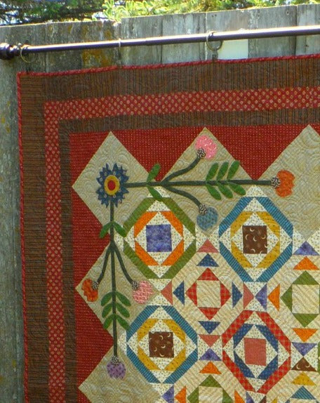 Detail view of scrappy lap quilt designed by Deanne Eisenman for Snuggles Quilts